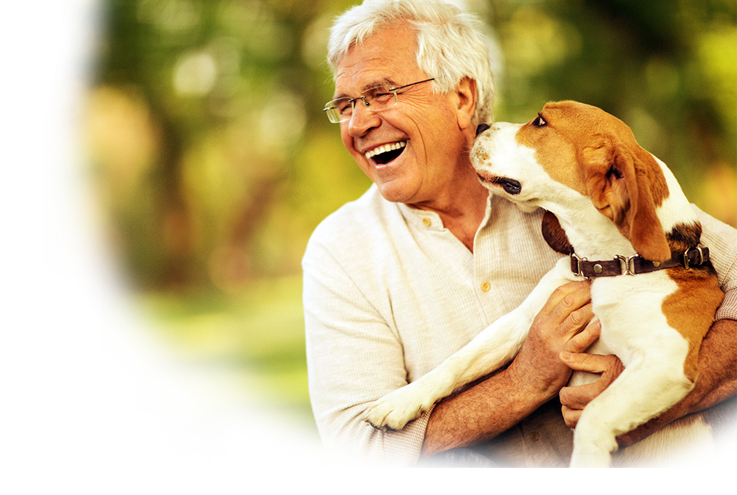 A man smiling while holding his dog